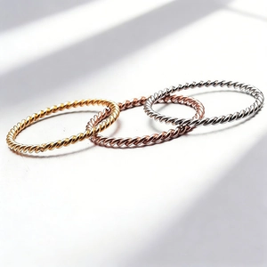 Macro shot of three-piece set rope twisted rings in gold, rose gold and silver finish