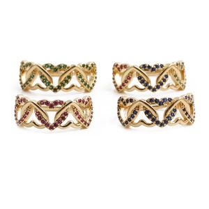 Intertwined heart-shaped gold rings with colorful crystals in green, red, and blue