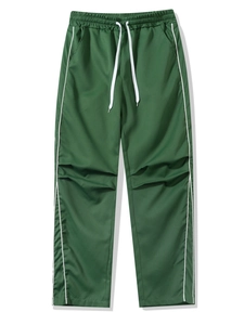 Detail of green sports trousers showing elastic waistband, white drawstrings and side stripes