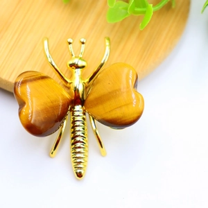 Detailed close-up of tiger eye stone butterfly wings set in golden alloy frame