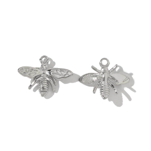 Detail view of two polished silver stainless steel bee pendants with attachment loops
