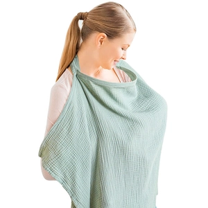 Detail shot of breathable cotton nursing cover in light green for breastfeeding mothers.