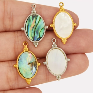 Detailed view of 304 stainless steel oval pendants with natural abalone and white shells