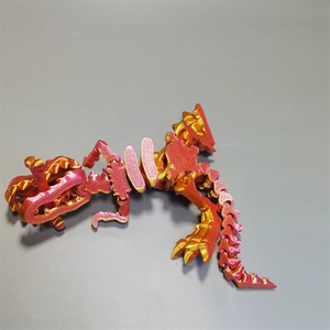 Top-down view of a 3D printed T-Rex skull with red and gold articulated movable joints