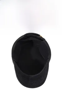 Detail of black winter flat cap featuring thick thermal lining and foldable ear flaps