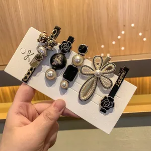5-piece French luxury hair clip set with gold bear, pearls, and black resin designs