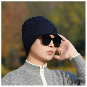 Detail of navy blue winter knit hat with brim and ribbed texture on male model