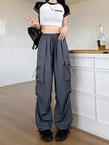 Detail of dark gray cargo pants showing high waist drawstring and large side pockets
