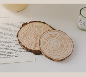 Close-up of round wooden candle trays with natural grain texture and rustic bark edges