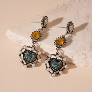 Dettaglio orecchini cuore vintage con cristallo ambra e strass blu brillanti