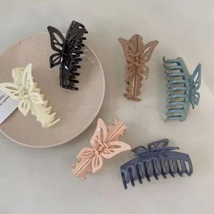 Detailed view of colorful butterfly hair claws in Morandi matte finish tones