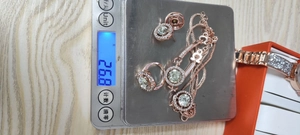 Detailed view of luxury jewelry set weight showing necklace and ring on a digital scale