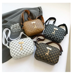 Flat lay of vintage monogram camera bags in four colors with gold deer pendant