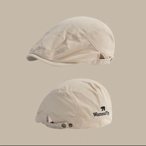 Close-up of beige cotton canvas newsboy cap with metal buckle and bear embroidery