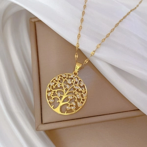 Detailed close-up of a gold tree of life pendant with sparkling crystals and fine chain