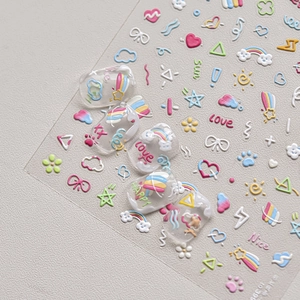Detail of 3D embossed nail stickers featuring colorful hearts, rainbows and clouds