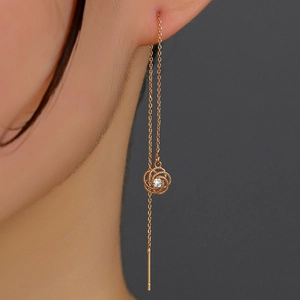 Close-up of rose gold tassel earrings with rose hollow pendant and sparkling zircon