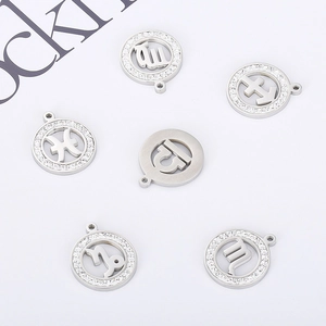Macro shot of gold-plated zodiac pendants with rhinestone borders and cutout symbols