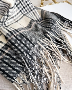 Macro shot of thick black and white plaid scarf fabric with elegant fringe tassels detail