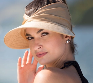 Close-up of a women's light beige sun visor cap shown from a side-back view outdoors