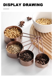 Detail of rose gold stainless steel measuring cups with long handles and pour spouts
