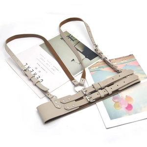 Detailed view of beige leather body harness with adjustable metal buckles and silver rivets