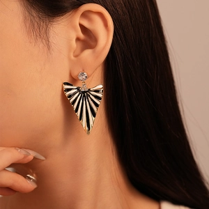Detail of vintage gold triangle earring with black and white stripes and zircon crystal