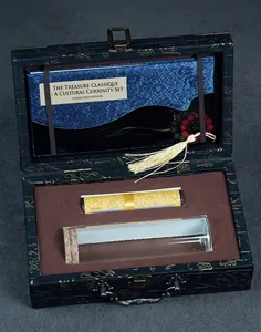Detail of luxury silk jewelry box with ancient scroll and antique book set for collector