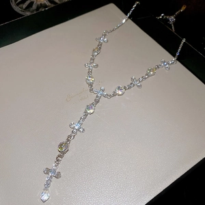 Detailed view of silver Y-necklace with crystal crosses and iridescent water drop pendant