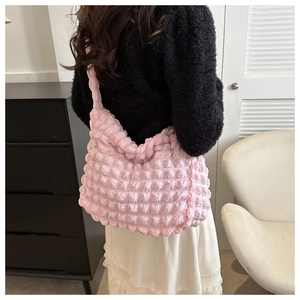 Rear view of a model wearing the pink bubble textured cloud tote bag in a cozy room