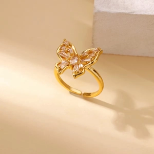 Macro detail of adjustable gold butterfly ring with inlaid rectangular zircon stones