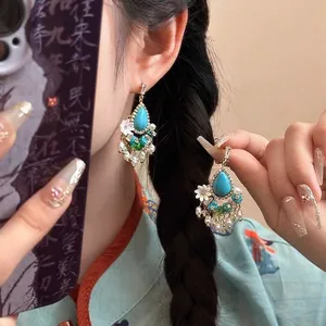 Gros plan détaillé de boucles d'oreilles ethniques avec turquoise et pampilles de perles