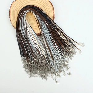 Detail of multi-color necklace cords with lobster clasps on a natural wood slice