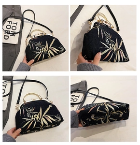 Detailed close-up of bamboo embroidery on vintage black velvet handbag with gold hardware