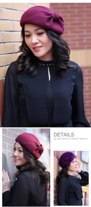 Detail view of burgundy wool beret with elegant bow decoration and vintage texture