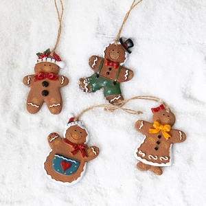 Set of 4 gingerbread man Christmas tree ornaments on snow background with rustic twine strings