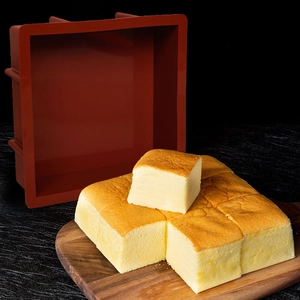 Grote vierkante siliconen bakvorm in donkerrood met goudbruine gebakken cake