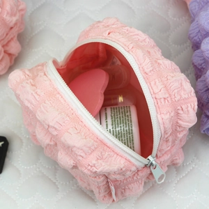 Detailed close-up of pink puff quilted makeup bag showing spacious interior and zipper