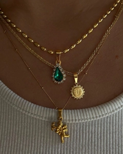 Gros plan sur les colliers superposés plaqués or 18 carats avec pendentifs soleil