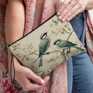 Portable makeup bag with bird and flower print and a black wristlet strap