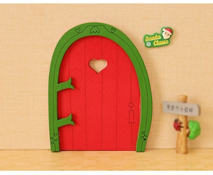 Detailed view of mini wooden Christmas elf door with heart cutout and green frame