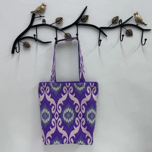 Detail of purple Ikat pattern tote bag hanging on a decorative metal wall hook