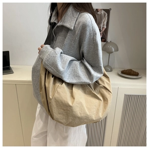 Close-up of khaki oversized slouchy hobo bag with nylon texture on a female model
