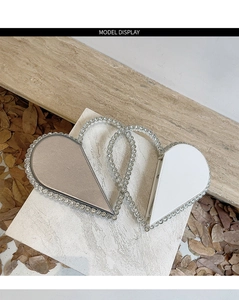 Detail of heart-shaped evening clutch bags with sparkling crystal edges on stone