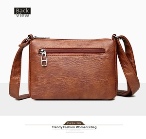 Rear view of brown crossbody bag featuring soft leather texture and zipper pocket