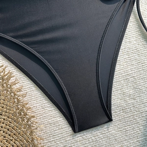 Détail d'un maillot de bain noir avec coutures renforcées à double aiguille et tissu élastique