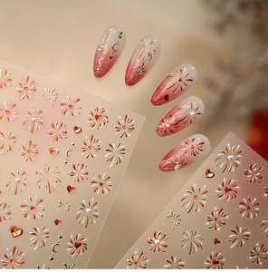 Macro detail of red and gold heart firework nail stickers with shimmering metallic texture