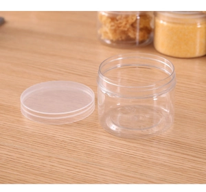 Close-up of a clear plastic storage jar with a frosted screw cap on a wooden table
