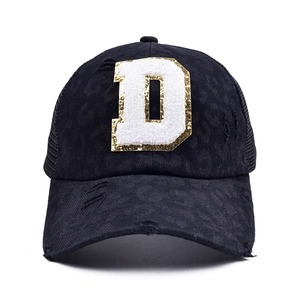 Detail of black baseball cap with leopard print, towel-embroidered D letter and mesh back