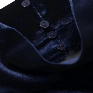 Detail shot of navy blue velvet dress featuring elegant round button closure on fabric